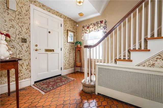 64 Riverfarm Rd, Cranston, RI 02910 - entryway with wallpapered walls, stairway, and radiator heating unit
