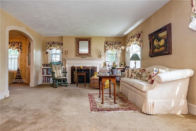 64 Riverfarm Rd, Cranston, RI 02910 - living room with arched walkways, carpet, and a brick fireplace