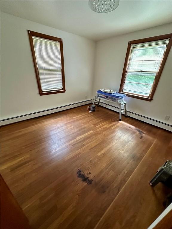 103 Windsor Park Dr, Coventry, RI 02816 - unfurnished bedroom featuring wood finished floors and a baseboard radiator