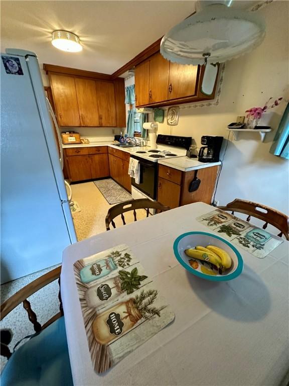 103 Windsor Park Dr, Coventry, RI 02816 - kitchen with white appliances, brown cabinetry, and light countertops