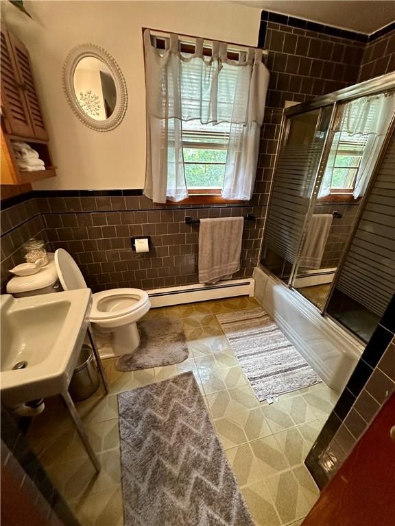 103 Windsor Park Dr, Coventry, RI 02816 - full bath with a baseboard heating unit, tile walls, a wainscoted wall, combined bath / shower with glass door, and tile patterned flooring