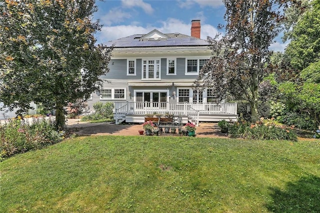 29 Orchard Ave, Providence, RI 02906 - rear view of property featuring a chimney, a yard, a wooden deck, and roof mounted solar panels