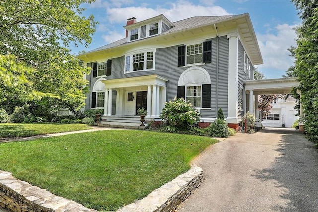 29 Orchard Ave, Providence, RI 02906 - view of front of home featuring driveway, a chimney, a front yard, covered porch, and a carport