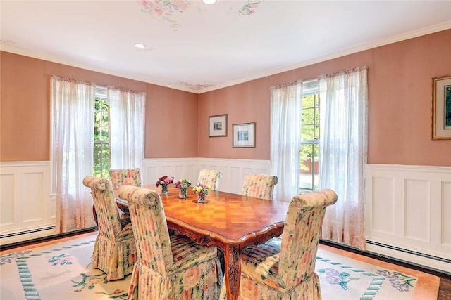 29 Orchard Ave, Providence, RI 02906 - dining area with wainscoting, a baseboard heating unit, a decorative wall, wood finished floors, and ornamental molding