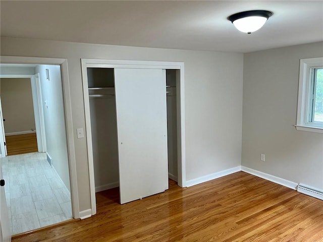 18 Louisiana Ave, Warwick, RI 02888 - unfurnished bedroom with wood finished floors, a closet, and a baseboard heating unit