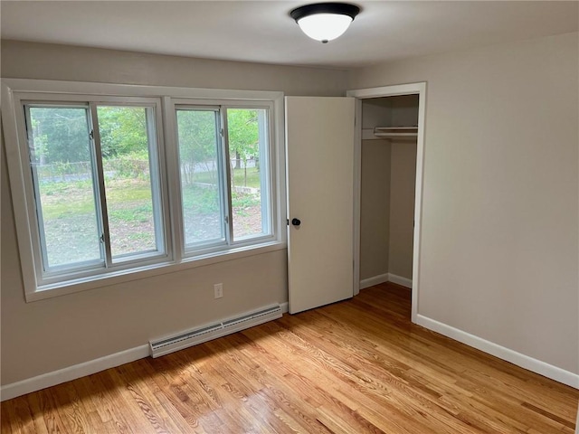 18 Louisiana Ave, Warwick, RI 02888 - unfurnished bedroom featuring a baseboard heating unit, a closet, and light wood-style flooring
