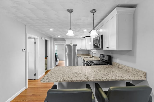 160 Coburn St, Warwick, RI 02889 - kitchen with appliances with stainless steel finishes, a peninsula, a breakfast bar, white cabinets, and recessed lighting
