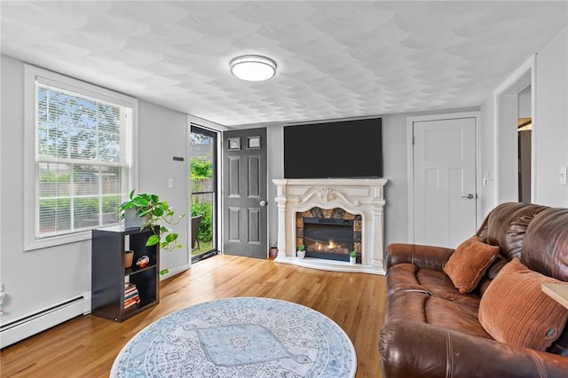 160 Coburn St, Warwick, RI 02889 - living area with a baseboard heating unit, wood finished floors, and a lit fireplace