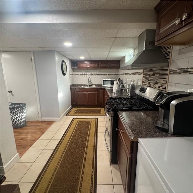 34 Ridge St, East Providence, RI 02914 - kitchen with wall chimney range hood, appliances with stainless steel finishes, light tile patterned floors, decorative backsplash, and a paneled ceiling