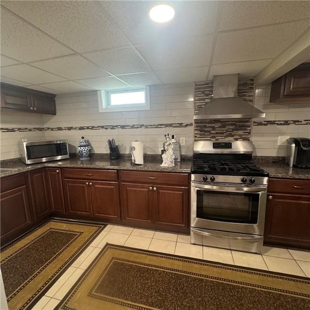 34 Ridge St, East Providence, RI 02914 - kitchen featuring stainless steel appliances, wall chimney exhaust hood, a paneled ceiling, decorative backsplash, and light tile patterned floors