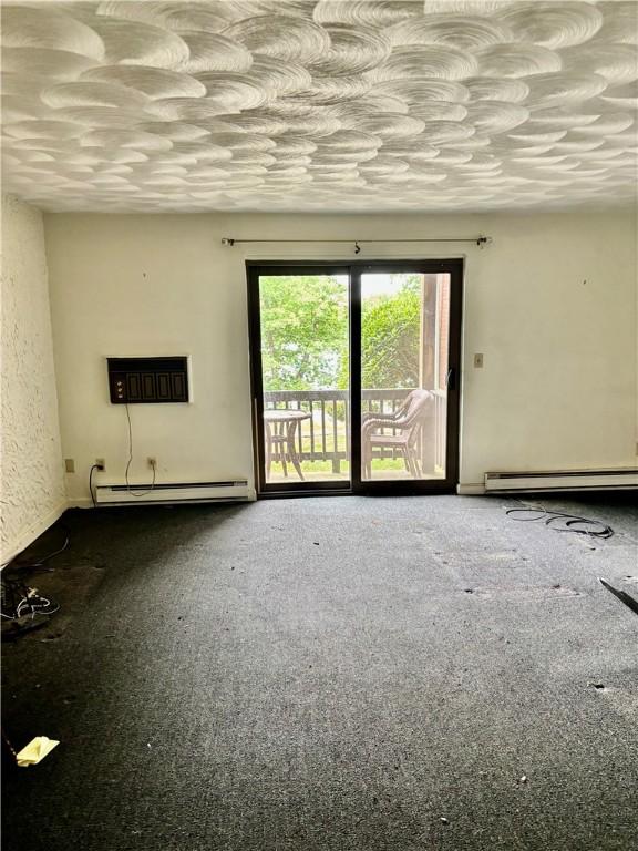 1190 Charles St Unit 9, North Providence, RI 02904 - unfurnished room with a baseboard heating unit, a wall mounted air conditioner, and carpet