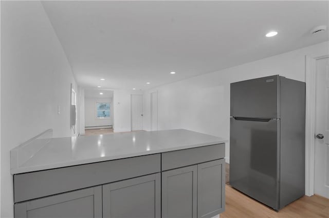 15 Maplewood Ave, Warwick, RI 02889 - kitchen with freestanding refrigerator, gray cabinets, light countertops, light wood-style floors, and a peninsula