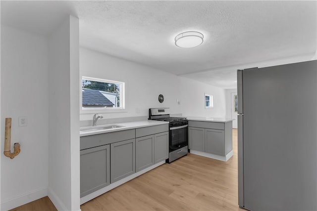 15 Maplewood Ave, Warwick, RI 02889 - kitchen featuring stainless steel appliances, gray cabinetry, light wood-style floors, light countertops, and a textured ceiling