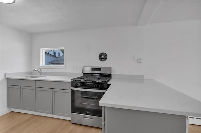 15 Maplewood Ave, Warwick, RI 02889 - kitchen with stainless steel gas stove, gray cabinets, light wood-style floors, light countertops, and baseboard heating