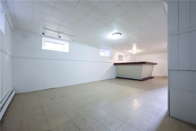 83 Vincent Ave, North Providence, RI 02904 - below grade area featuring a baseboard radiator, rail lighting, light floors, and bar area