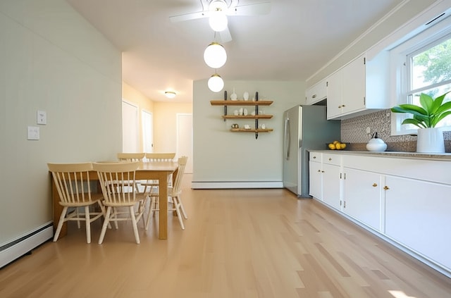 83 Vincent Ave, North Providence, RI 02904 - kitchen with a baseboard radiator, light wood-type flooring, white cabinets, a ceiling fan, and tasteful backsplash