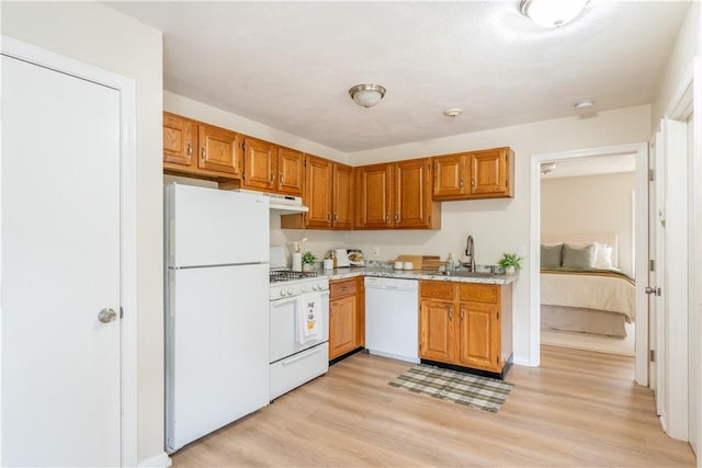 10 E St Unit 207, Cranston, RI 02920 - kitchen featuring white appliances, light wood finished floors, under cabinet range hood, and brown cabinetry