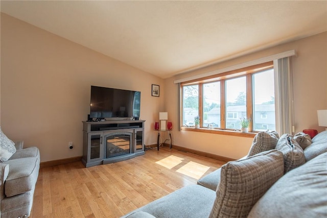 14 Gateway Ct, Warwick, RI 02889 - living area with light wood-style floors, lofted ceiling, and a glass covered fireplace