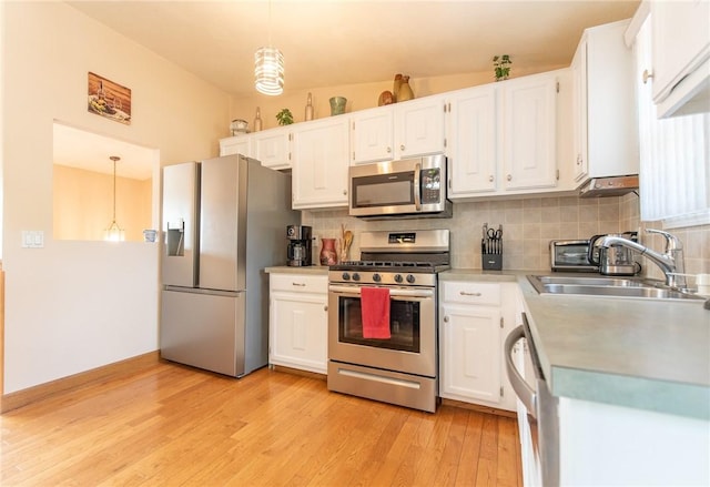 14 Gateway Ct, Warwick, RI 02889 - kitchen with appliances with stainless steel finishes, backsplash, white cabinets, and light wood-style floors