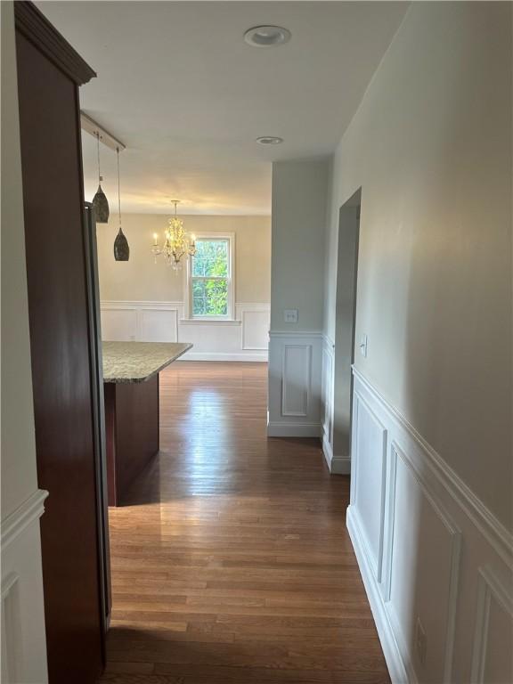 6 Larkspur Rd, Warwick, RI 02886 - corridor featuring a decorative wall, a chandelier, dark wood finished floors, and wainscoting