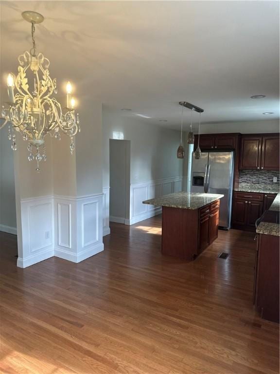 6 Larkspur Rd, Warwick, RI 02886 - kitchen featuring stainless steel refrigerator with ice dispenser, a kitchen island, stone countertops, dark wood finished floors, and wainscoting