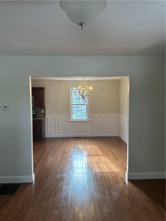 6 Larkspur Rd, Warwick, RI 02886 - unfurnished dining area featuring a chandelier, dark wood-style flooring, and a wainscoted wall