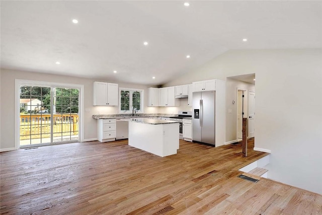 25 Walling Rd, Burrillville, RI 02830 - kitchen with appliances with stainless steel finishes, a kitchen island, light wood-style floors, white cabinetry, and lofted ceiling