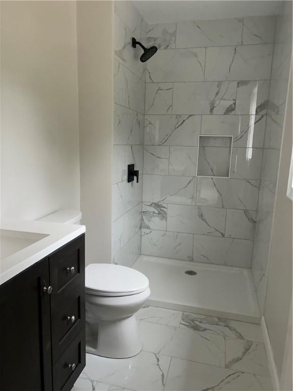 25 Walling Rd, Burrillville, RI 02830 - bathroom featuring vanity, marble look tiles, and a tile shower