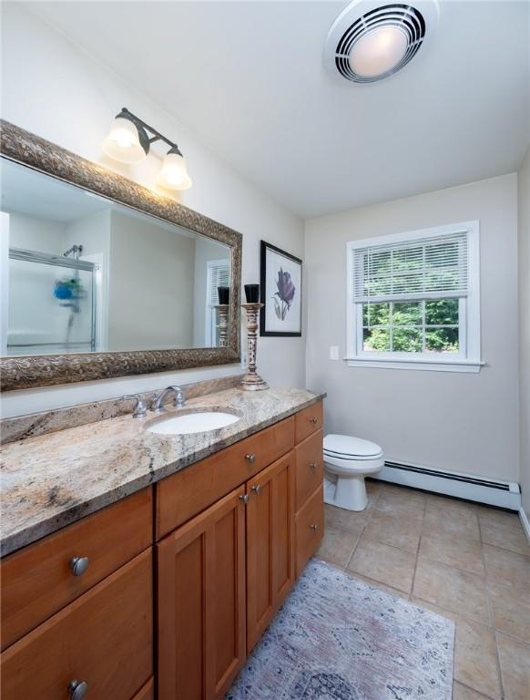 2 Elizabeth Ann Dr, Johnston, RI 02919 - full bathroom featuring a baseboard heating unit, vanity, a shower with door, and tile patterned floors