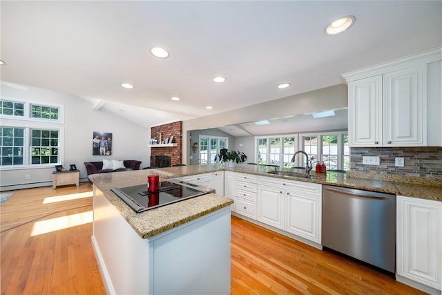 2 Elizabeth Ann Dr, Johnston, RI 02919 - kitchen with stainless steel dishwasher, black electric stovetop, a fireplace, light wood-type flooring, and white cabinetry