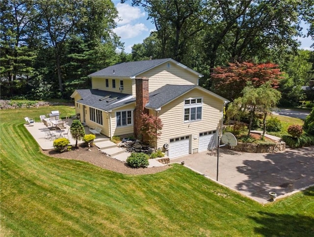 2 Elizabeth Ann Dr, Johnston, RI 02919 - back of property with a garage, driveway, a lawn, a patio, and roof with shingles