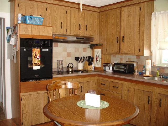 115 Slater Park Ave, Pawtucket, RI 02861 - kitchen with under cabinet range hood, black appliances, backsplash, and light countertops