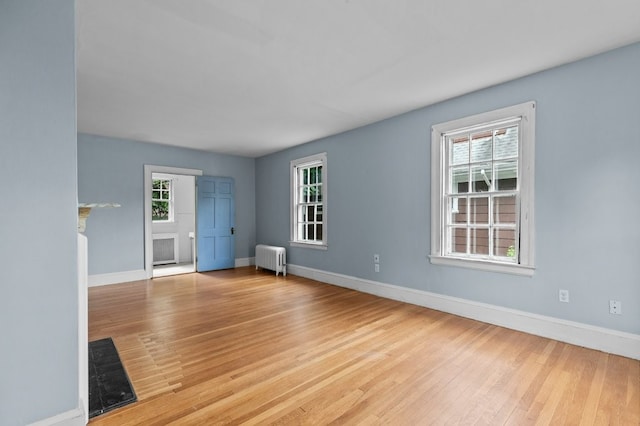 189 Butler Ave, Providence, RI 02906 - unfurnished living room with radiator heating unit, wood finished floors, and a fireplace