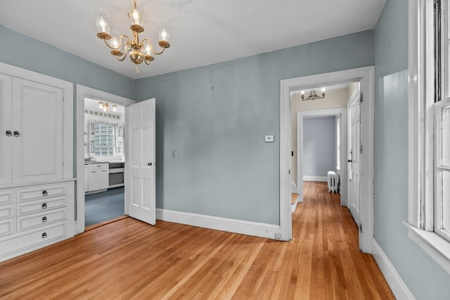 189 Butler Ave, Providence, RI 02906 - unfurnished bedroom with a chandelier and light wood-type flooring