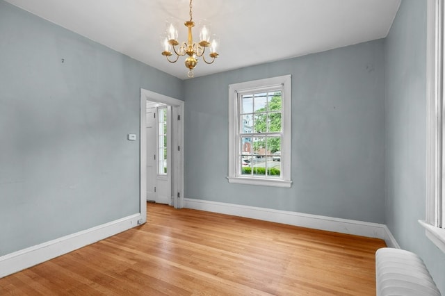 189 Butler Ave, Providence, RI 02906 - empty room with radiator, a chandelier, and light wood finished floors