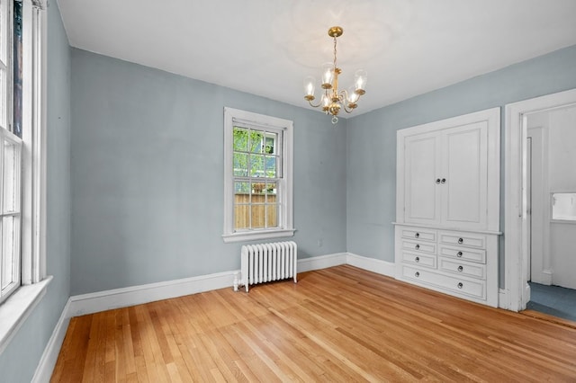 189 Butler Ave, Providence, RI 02906 - unfurnished bedroom featuring radiator, a chandelier, and light wood-style floors