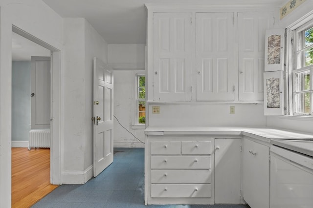 189 Butler Ave, Providence, RI 02906 - kitchen with radiator, white cabinets, light countertops, and dark floors