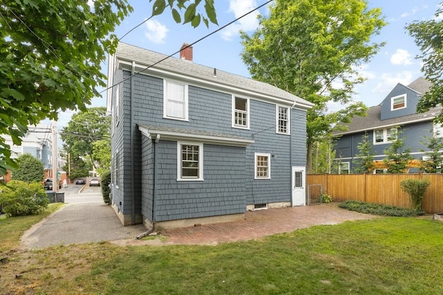 189 Butler Ave, Providence, RI 02906 - rear view of property featuring a chimney, a patio area, and roof with shingles