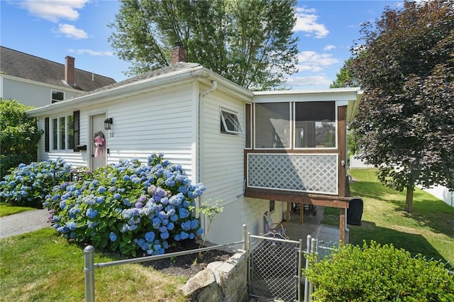 12 Elmore Ave, North Providence, RI 02911 - view of side of home featuring a chimney, a sunroom, and a gate