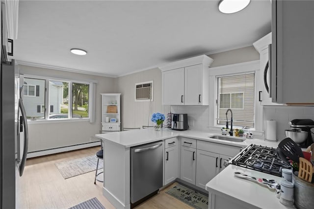 12 Elmore Ave, North Providence, RI 02911 - kitchen with dishwasher, a baseboard heating unit, a peninsula, light wood-style floors, and crown molding