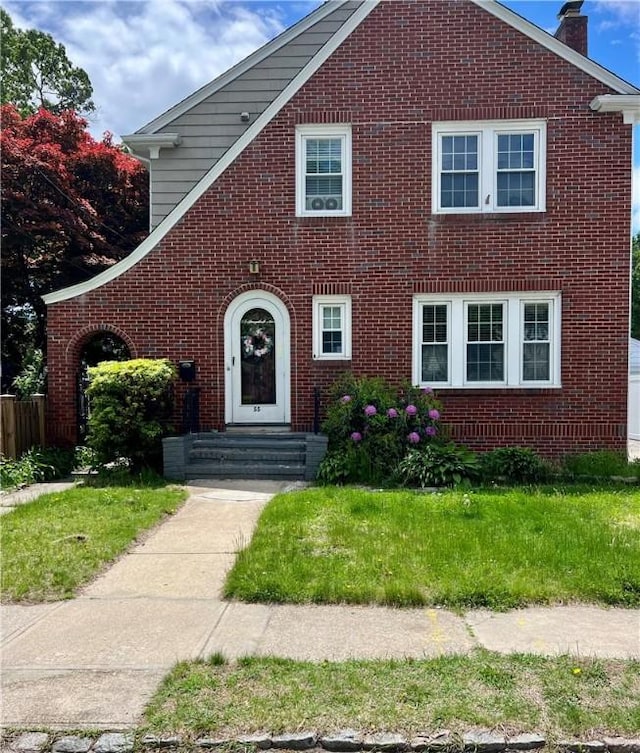 55 Greylock Ave, Cranston, RI 02910 - view of front of home with brick siding, a chimney, and a front lawn