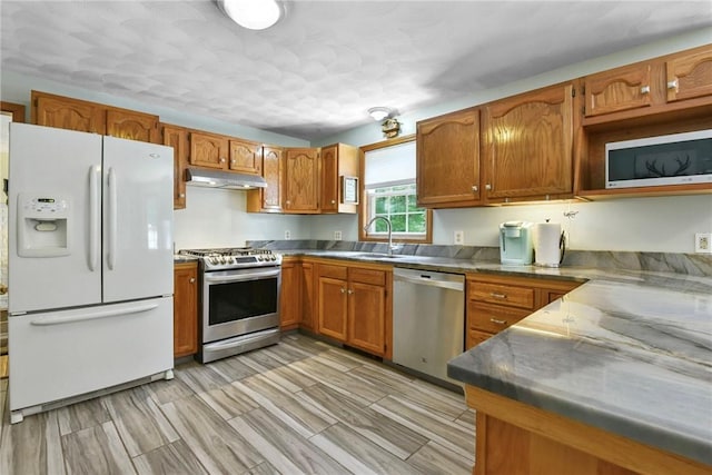 6 Ferris Dr, Coventry, RI 02816 - kitchen with stainless steel appliances, under cabinet range hood, and brown cabinetry