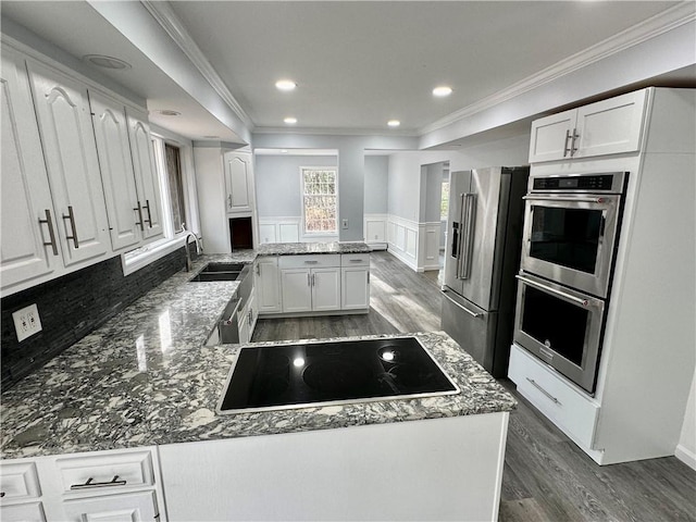 20 Biscuit Hill Rd, Foster, RI 02825 - kitchen featuring appliances with stainless steel finishes, dark wood-type flooring, ornamental molding, a peninsula, and white cabinetry