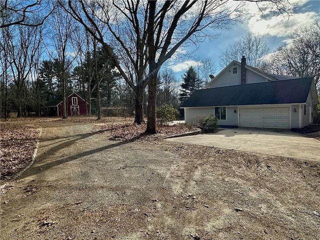 20 Biscuit Hill Rd, Foster, RI 02825 - view of side of property featuring concrete driveway, a chimney, and an attached garage