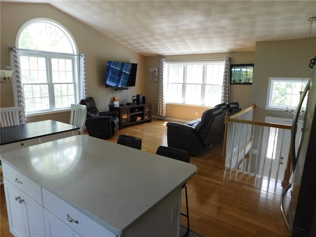 476 Ledge Rd, Coventry, RI 02816 - kitchen with wood finished floors, plenty of natural light, open floor plan, white cabinets, and lofted ceiling
