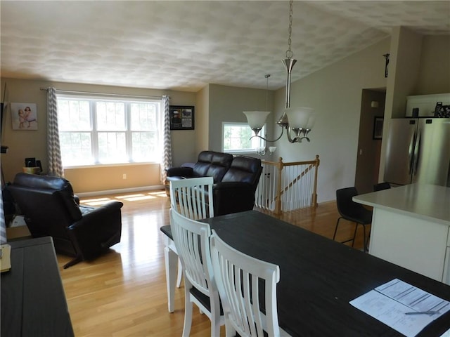 476 Ledge Rd, Coventry, RI 02816 - dining space featuring light wood-type flooring, vaulted ceiling, a chandelier, and a textured ceiling