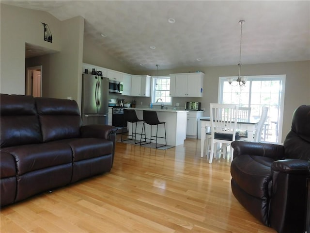 476 Ledge Rd, Coventry, RI 02816 - living room featuring light wood finished floors, a chandelier, and vaulted ceiling