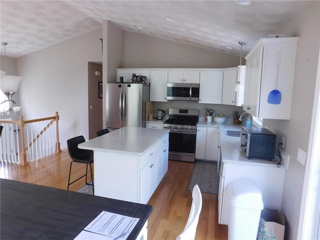476 Ledge Rd, Coventry, RI 02816 - kitchen with stainless steel appliances, light wood-style floors, lofted ceiling, white cabinets, and a center island