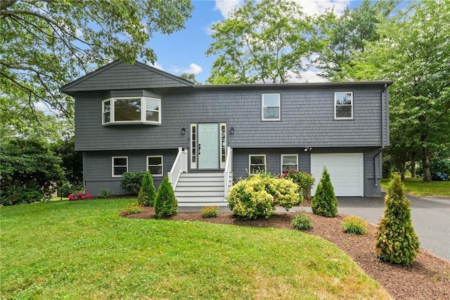 7 Antony Ave, Bristol, RI 02809 - split foyer home with an attached garage, a front lawn, and asphalt driveway