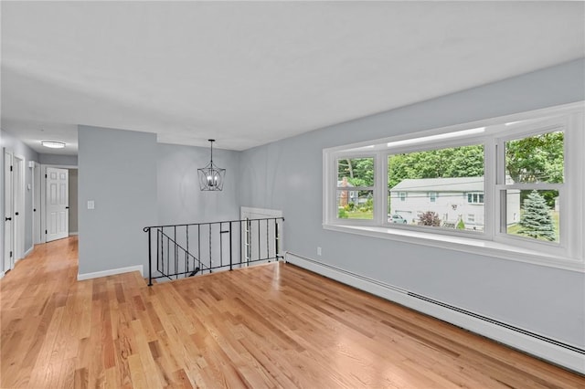 7 Antony Ave, Bristol, RI 02809 - empty room featuring a baseboard heating unit, light wood-style flooring, and a chandelier
